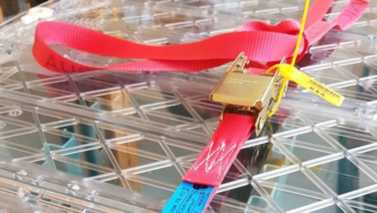Plastic box lashed by a webbing strap