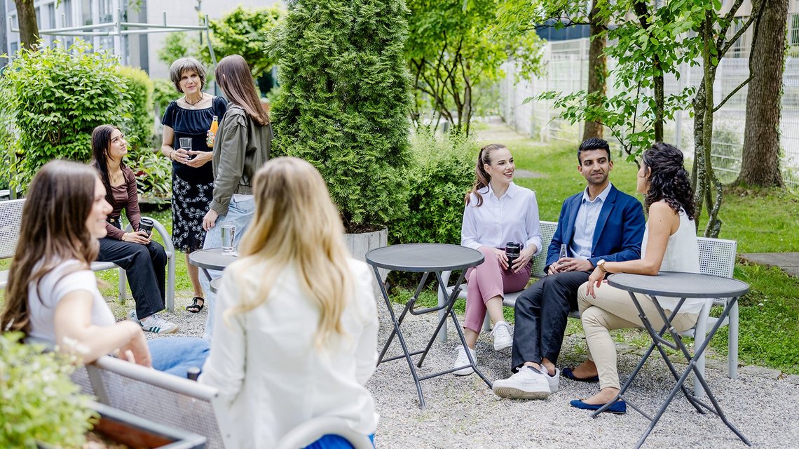 Group of colleagues conversing outdoors in a garden