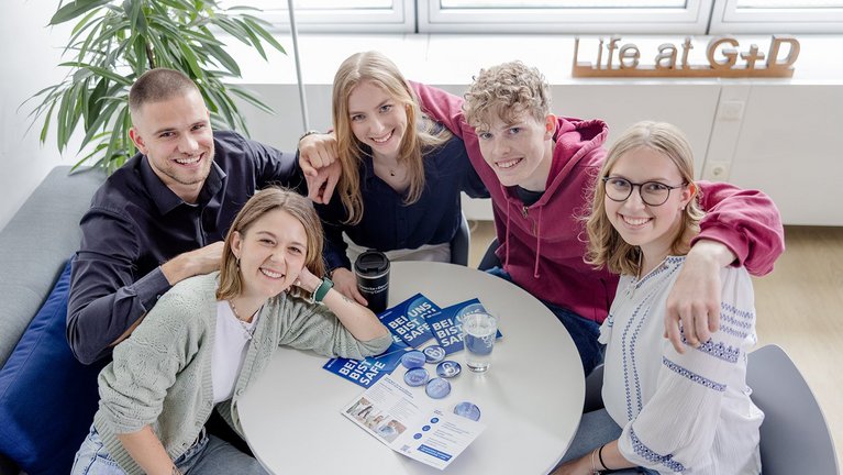 Young people sitting together at a table with info material and buttons
