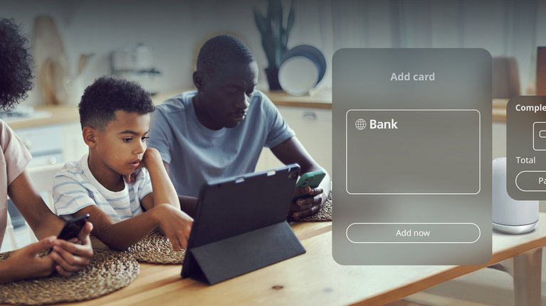 A family engages with digital devices around a table, with a digital payment interface displayed in the foreground showing a transaction option.