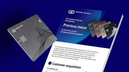 Promotional display for G+D showcasing metal credit cards and a flyer on the benefits of precious metals in payment programs.