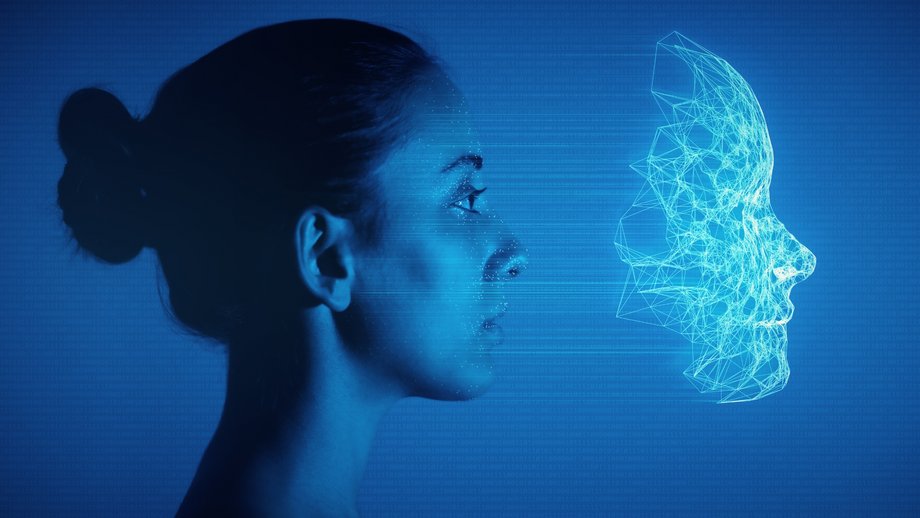 A woman looks at her digital 3D model of her face with mesh and recognition marks