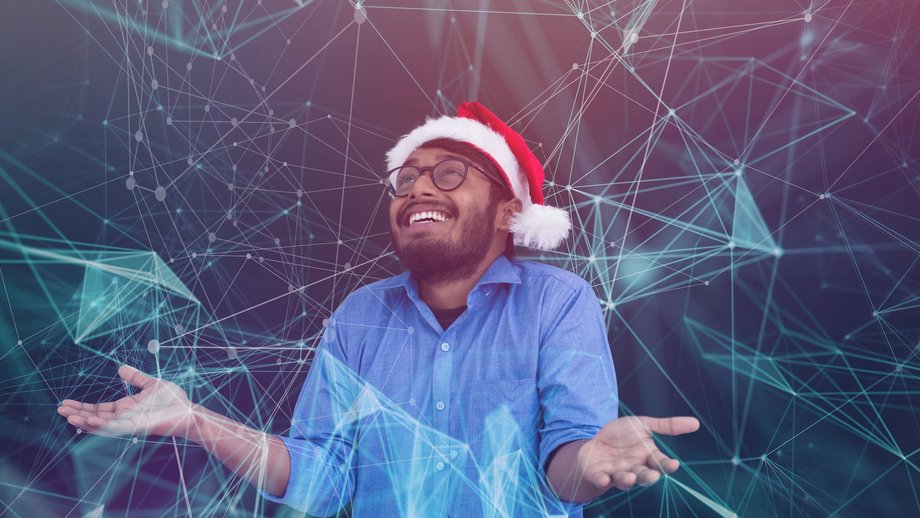 Person wearing a Santa hat with hands open, surrounded by a digital network of lines and nodes.