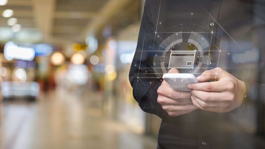 Person using a smartphone with a digital credit card icon overlay, representing mobile payments.
