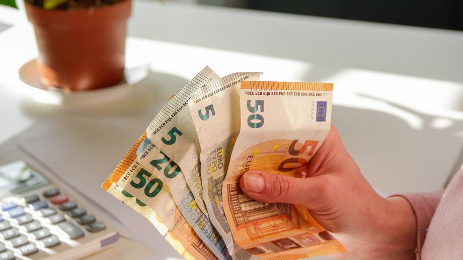 Hand holding various euro banknotes