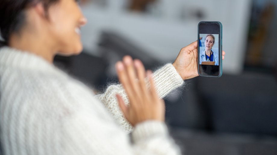 Person on video call with doctor on smartphone.
