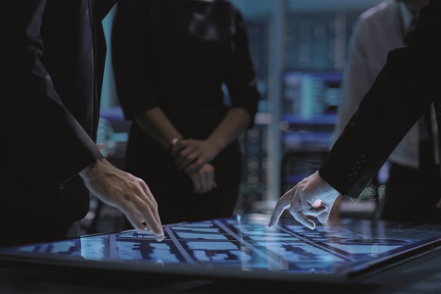 Hands of people pointing at a large touch screen