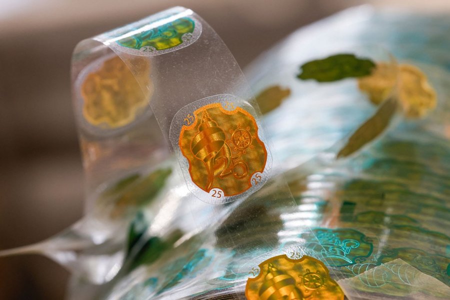 Holographic security stickers on transparent foil with maritime motifs and the number 25.