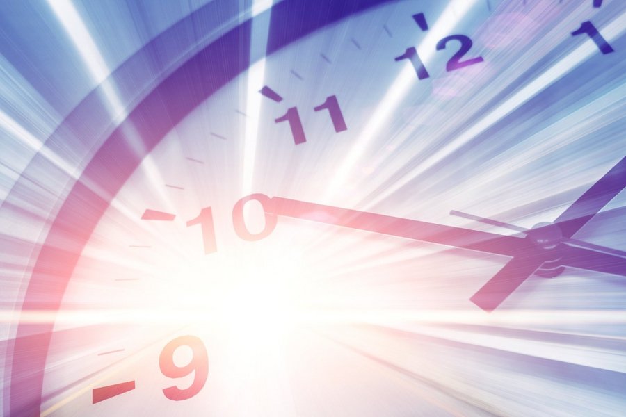 Blurred, dynamic close-up of a clock with light streaks symbolizing motion and time travel.