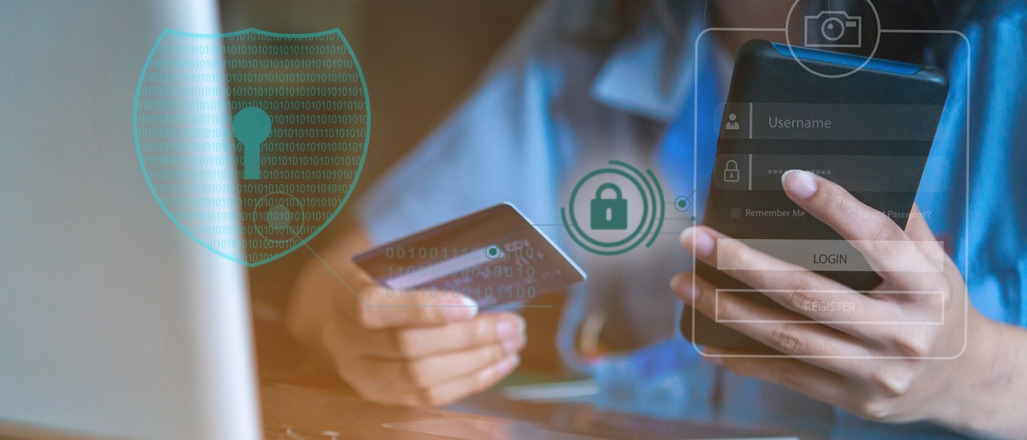 Person holding a smartphone and a credit card, digital security symbols.