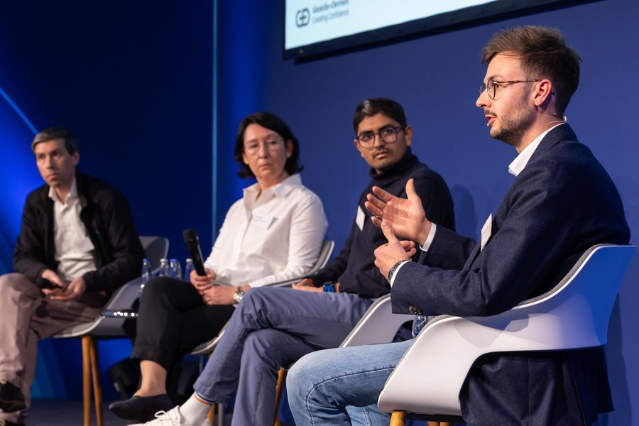 Four panelists from G+D’s Blockchain Thinkers event are sitting on the stage, discussing.