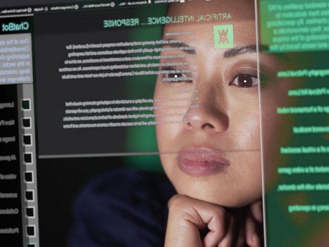 Asian woman studying a see-through screen, which is producing lines of AI generated text