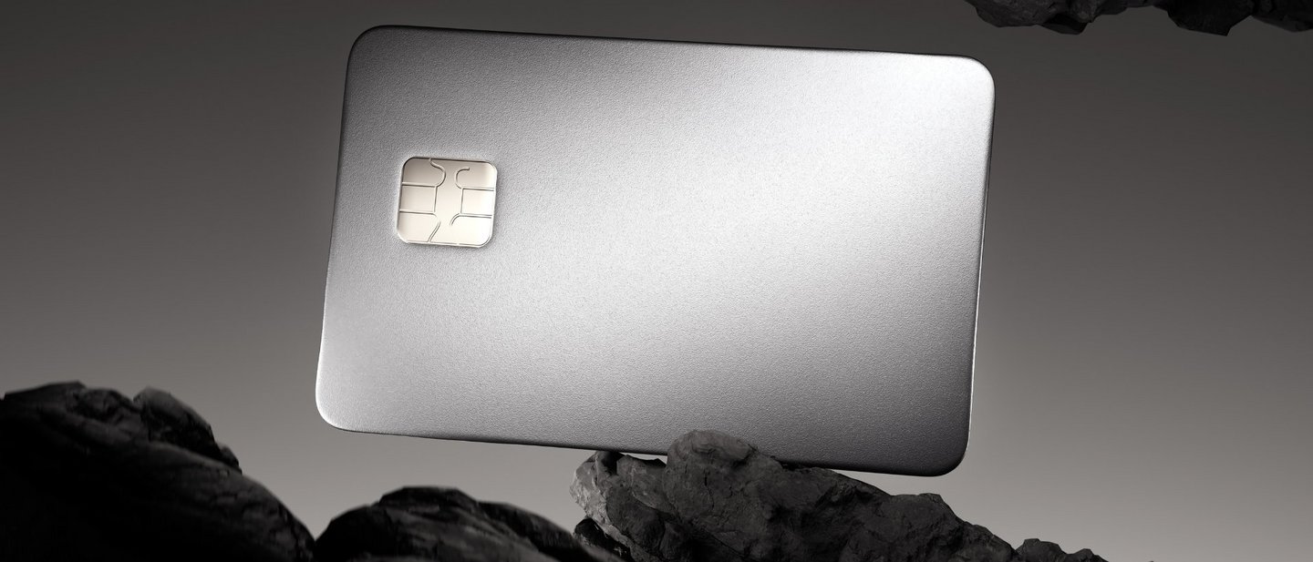 Luxurious, metallic credit card with a chip, dramatically lit, between dark, rocky formations
