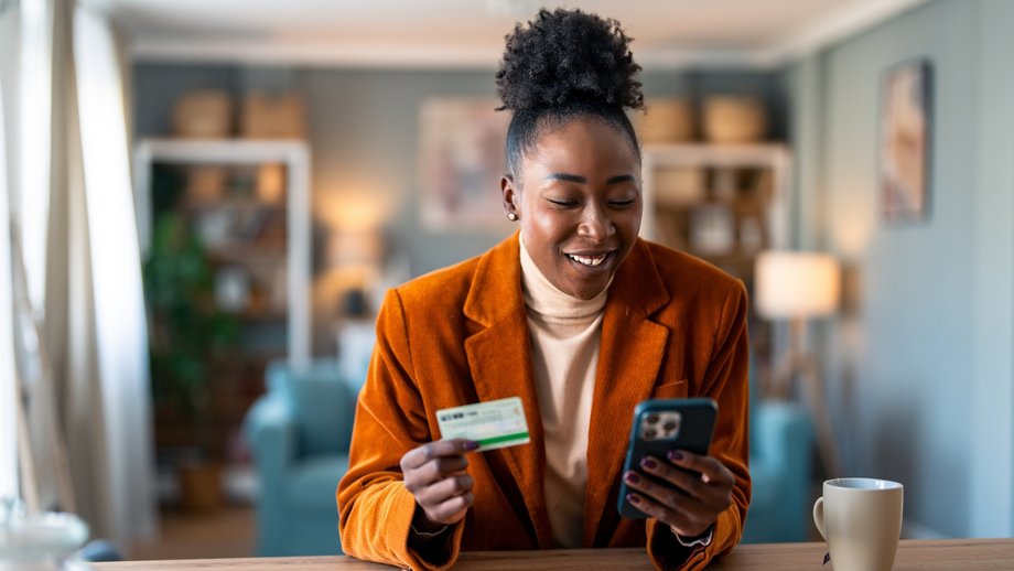 A Hispanic woman checks her last transaction through her digital wallet on her smartphone.