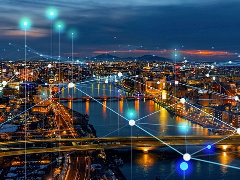 City skyline at night with illuminated network connections symbolizing digital communications