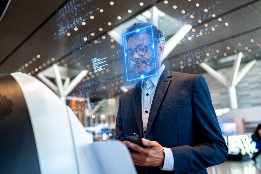 Ein Mann steht am Flughafen-Check-in mit Gesichtserkennung und testet so modernes Reisen.