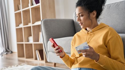 A woman holding a G+D Convego Metal Encased Card