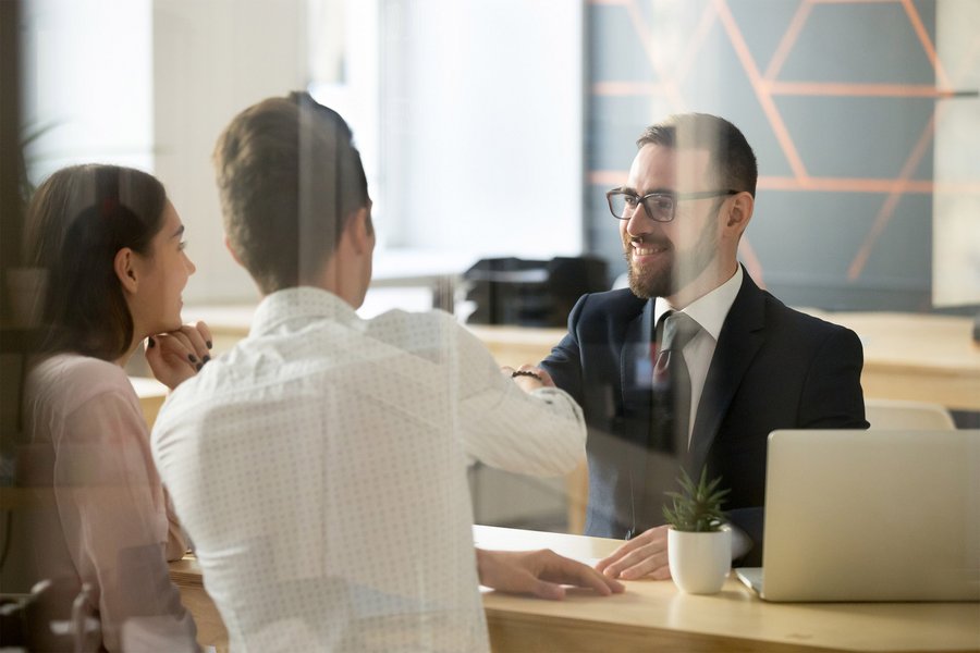 Handshake between two men and a woman in a sales situation