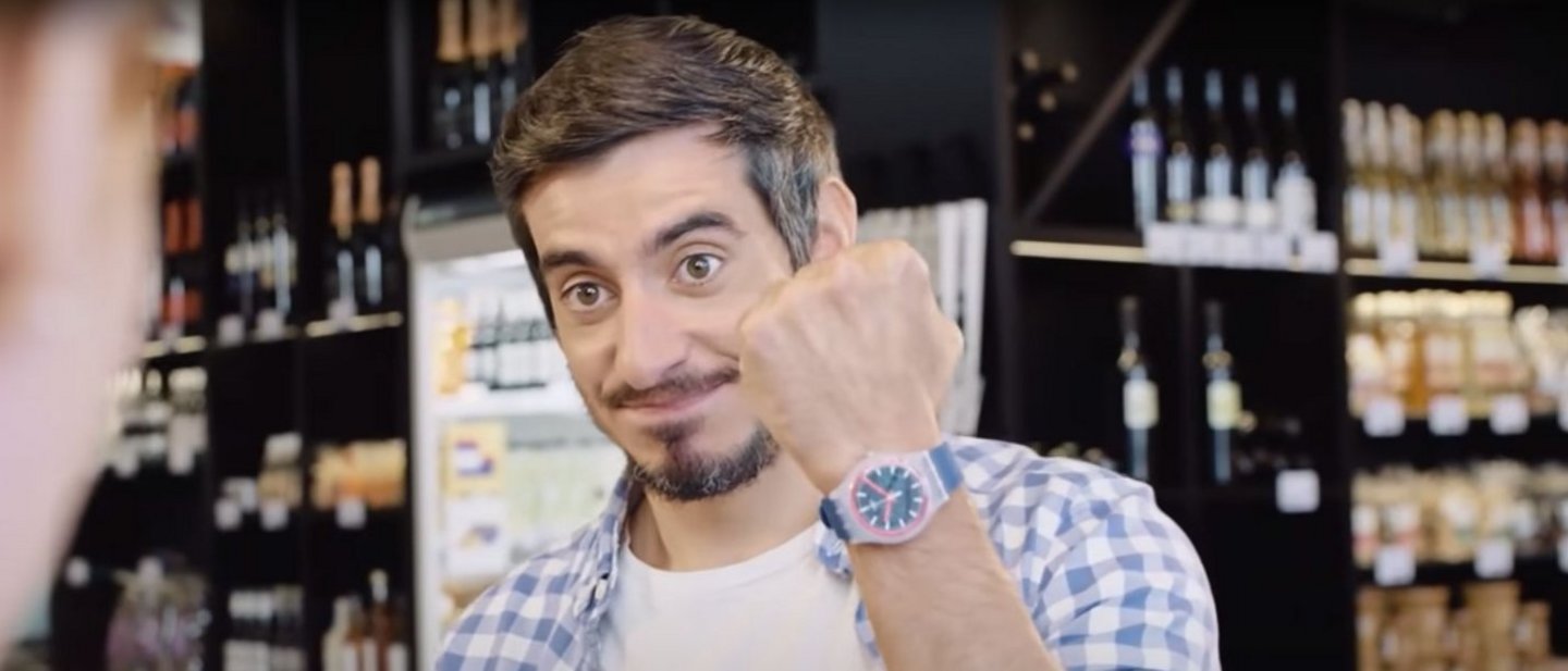 A man shows holds up his Swatch Pay watch which he will now pay for his coffee with