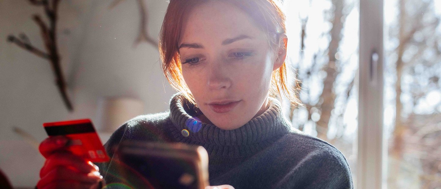 Woman shopping online with credit card using mobile phone.