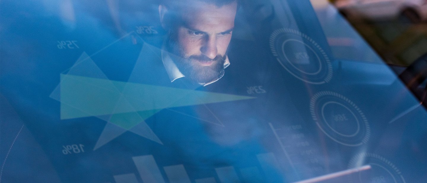 Man sitting in a car using the eSIM technology connected with his car and tablet