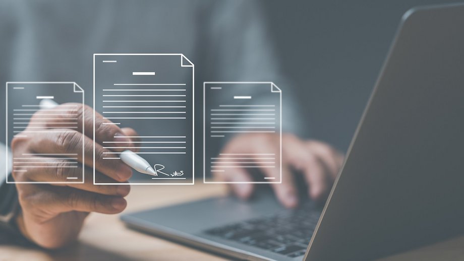 Ein Mann am Labtop, der digital Dokumente ausfüllt