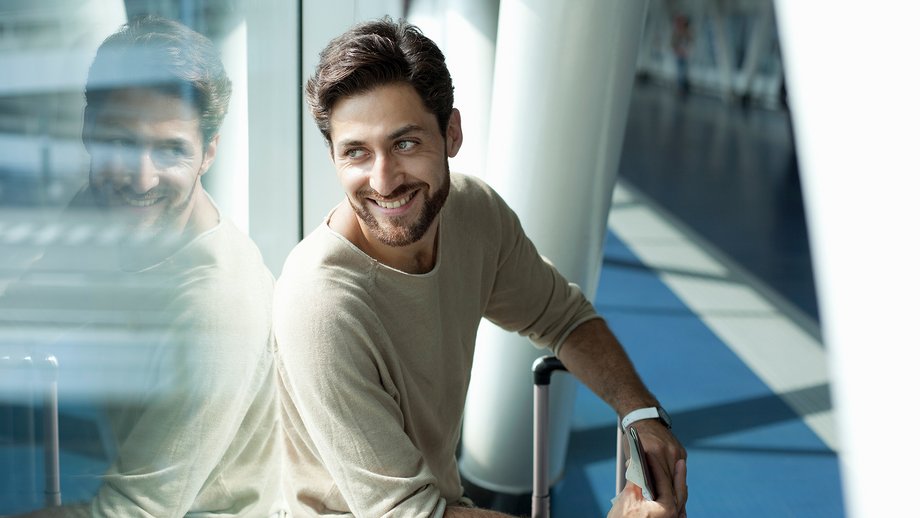 Man at airport, looking through window