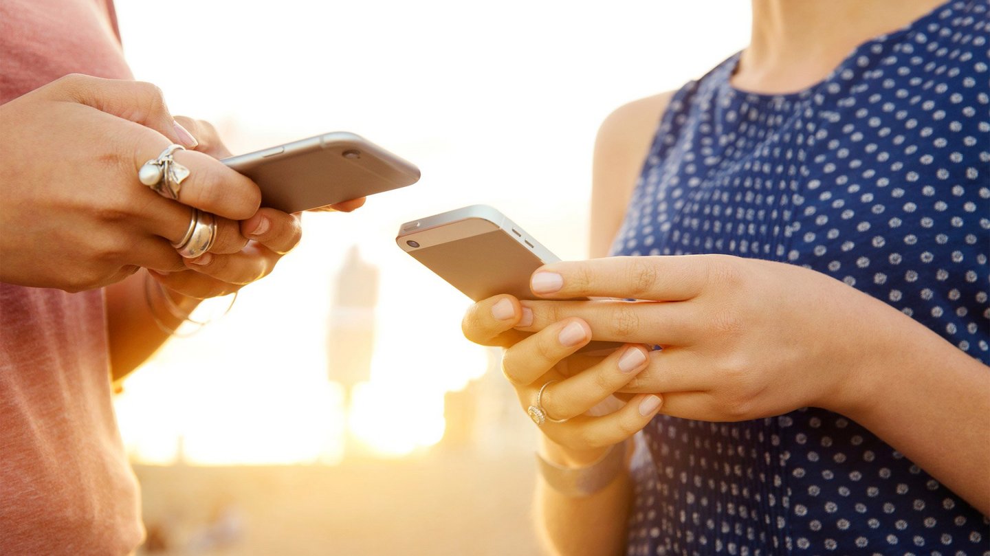 Two women using smart phones, close up