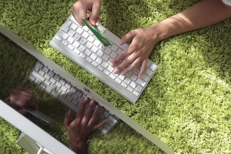 Close-up of a woman lying in the grass using sustainable bank cards online