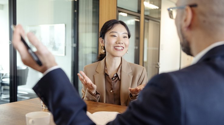 A woman and a man having a conversation in a meeting room