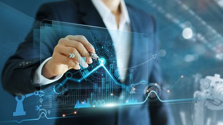 A man in a suit uses a fountain pen to operate a digital display with diagrams