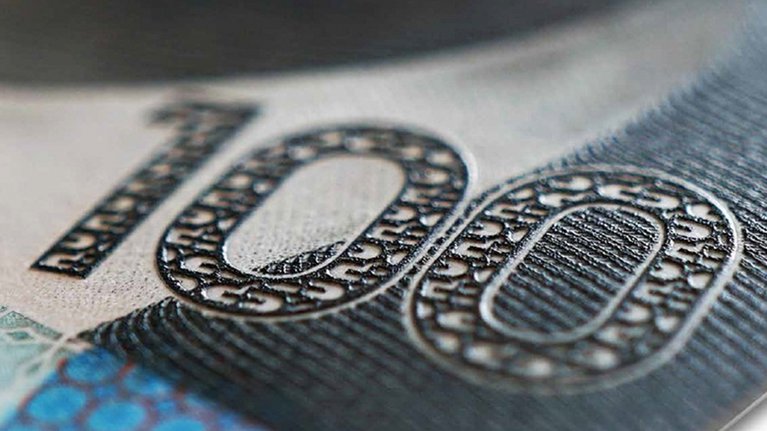 Close up of the number 100 on a banknote