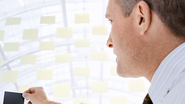 Business man pinning a post-it