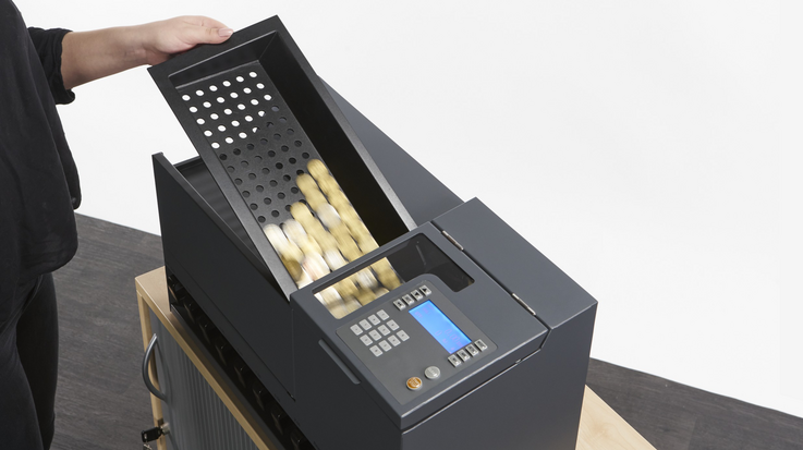 Coins are filled from a tray into the Coin 300 coin processing system