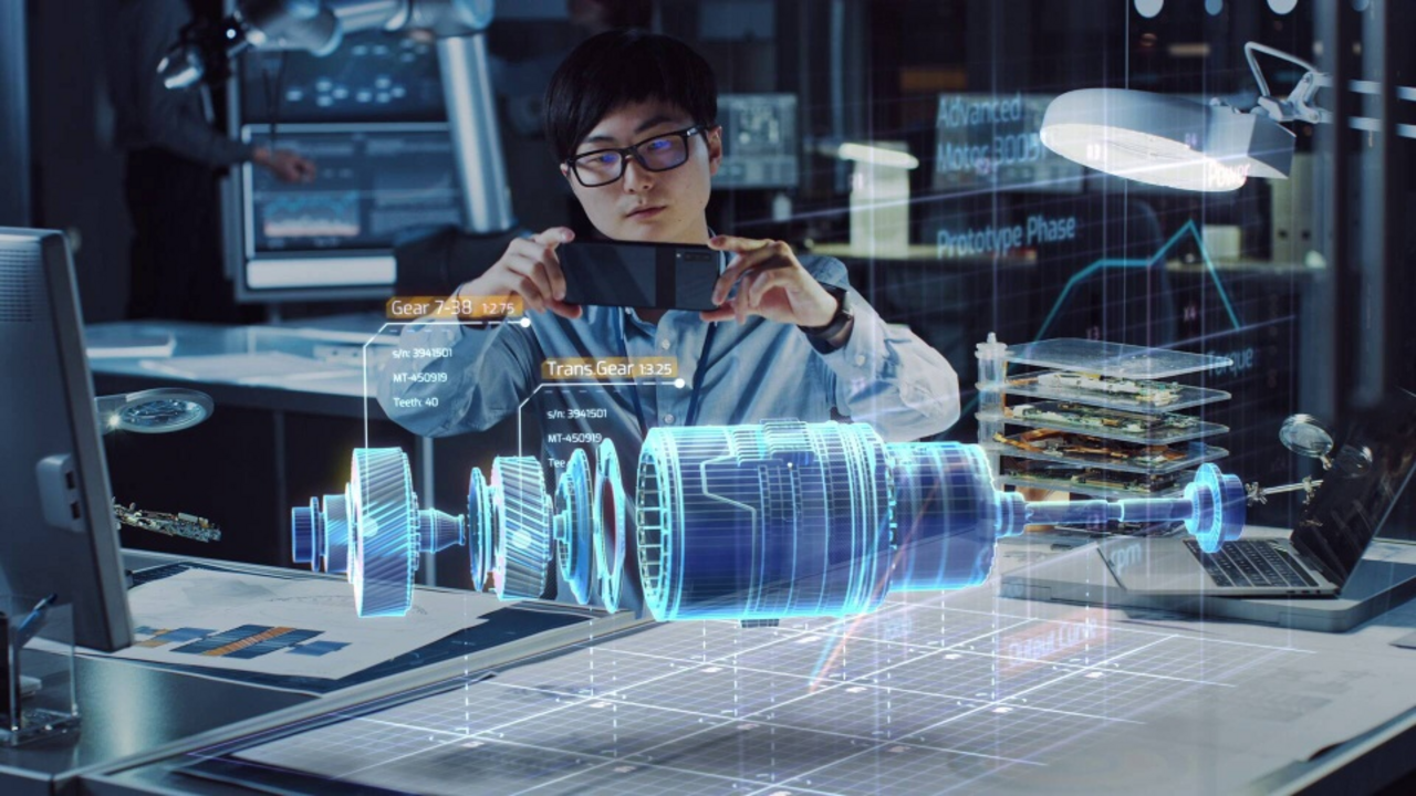 A person points their smartphone at 3D visualized components that appear in the air above a work surface