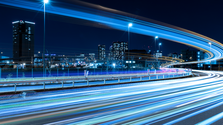 Image of a big city with light trails running through the streets